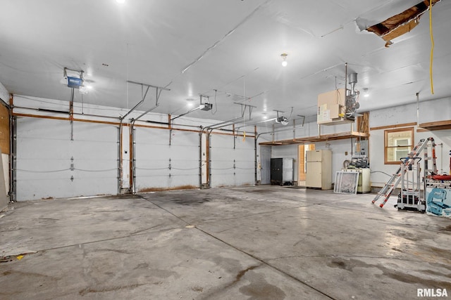 1426 N Main St, East Peoria, IL 61611 - garage featuring freestanding refrigerator, a garage door opener, and washer / clothes dryer
