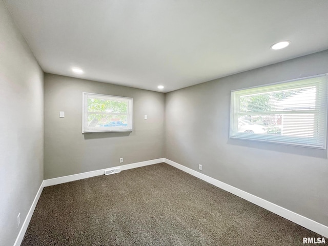 4914 N Bevalon Pl, Peoria, IL 61614 - empty room featuring healthy amount of natural light, dark colored carpet, and recessed lighting