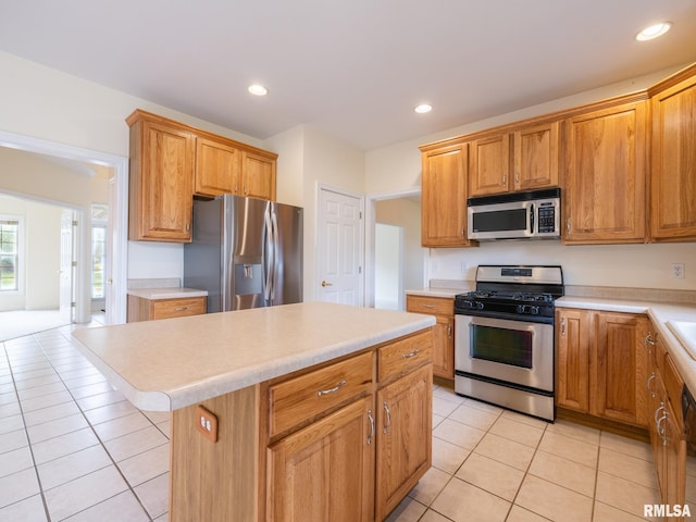 919 W Brookforest Dr, Peoria, IL 61615 - kitchen featuring appliances with stainless steel finishes, light tile patterned floors, light countertops, a kitchen island, and recessed lighting