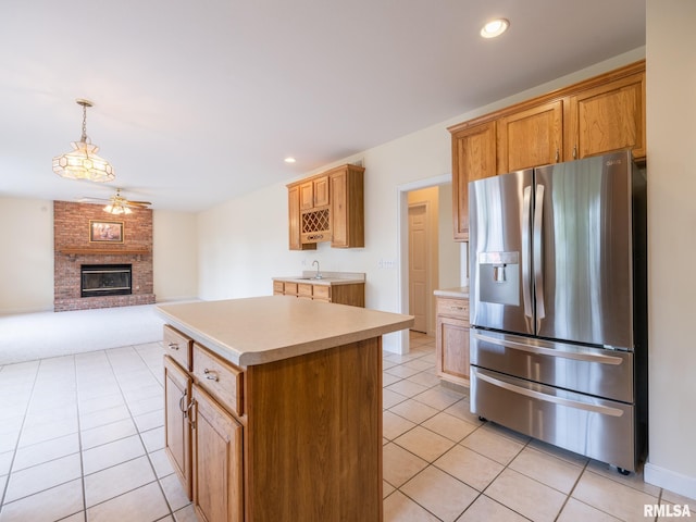 919 W Brookforest Dr, Peoria, IL 61615 - kitchen with stainless steel refrigerator with ice dispenser, light tile patterned flooring, light countertops, a fireplace, and recessed lighting
