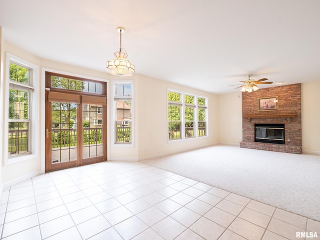 919 W Brookforest Dr, Peoria, IL 61615 - unfurnished living room with light carpet, healthy amount of natural light, light tile patterned floors, and a fireplace