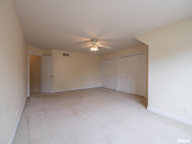 919 W Brookforest Dr, Peoria, IL 61615 - unfurnished bedroom featuring light carpet, multiple closets, and a ceiling fan