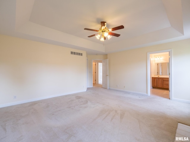 919 W Brookforest Dr, Peoria, IL 61615 - unfurnished bedroom featuring a raised ceiling, light colored carpet, ensuite bath, and ceiling fan