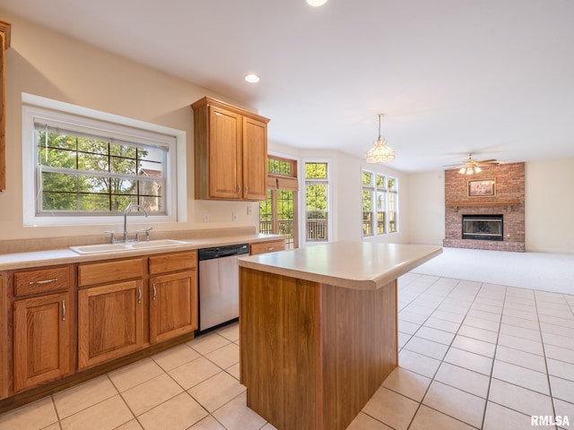 919 W Brookforest Dr, Peoria, IL 61615 - kitchen with stainless steel dishwasher, light tile patterned floors, light countertops, a kitchen island, and a fireplace
