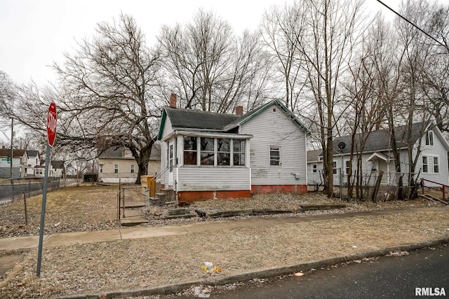 1300 W Martin St, Peoria, IL 61605 - view of front of property featuring a chimney, a sunroom, and a gate