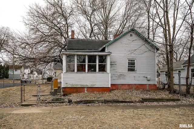 1300 W Martin St, Peoria, IL 61605 - back of property with a gate, a chimney, and roof with shingles