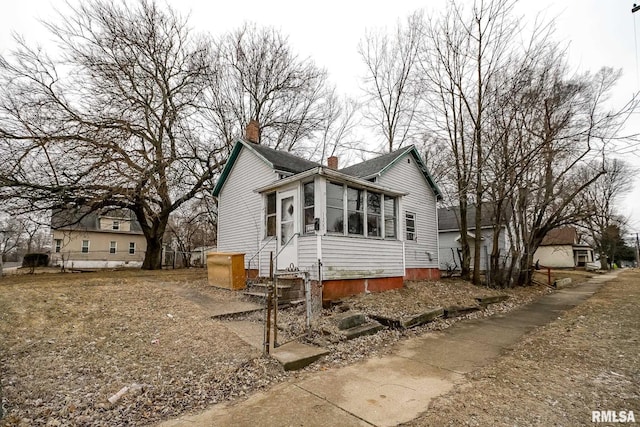 1300 W Martin St, Peoria, IL 61605 - view of front of home featuring a chimney and a sunroom