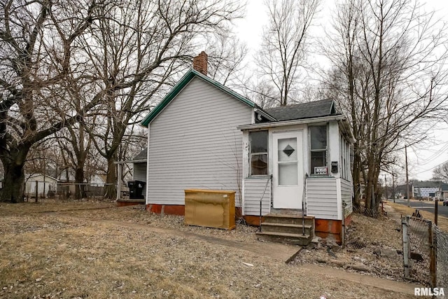 1300 W Martin St, Peoria, IL 61605 - rear view of house featuring entry steps, a chimney, and a shingled roof