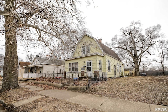 1929 Stanley St, Peoria, IL 61605 - view of front of home with a chimney and a fenced front yard