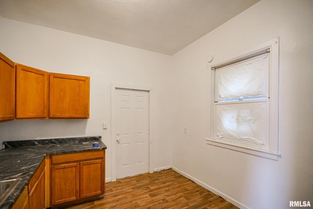 506 Spring St, Peoria, IL 61603 - kitchen with wood finished floors, dark countertops, and brown cabinetry