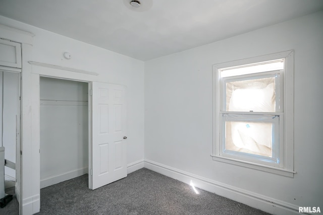 506 Spring St, Peoria, IL 61603 - unfurnished bedroom featuring a closet and dark carpet