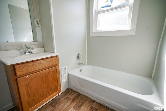 506 Spring St, Peoria, IL 61603 - bathroom featuring vanity, wood finished floors, and decorative backsplash
