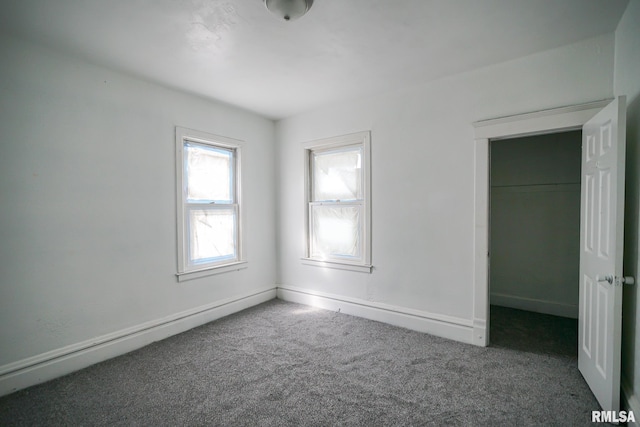 506 Spring St, Peoria, IL 61603 - unfurnished bedroom with carpet floors, a spacious closet, baseboard heating, and a closet