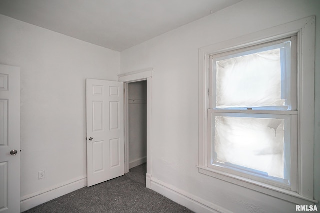 506 Spring St, Peoria, IL 61603 - unfurnished bedroom with dark colored carpet and baseboards