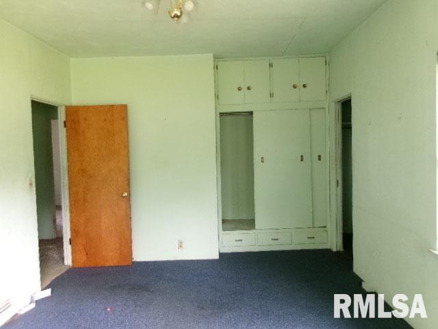215 N Prairie St, Lacon, IL 61540 - unfurnished bedroom featuring dark colored carpet and a closet