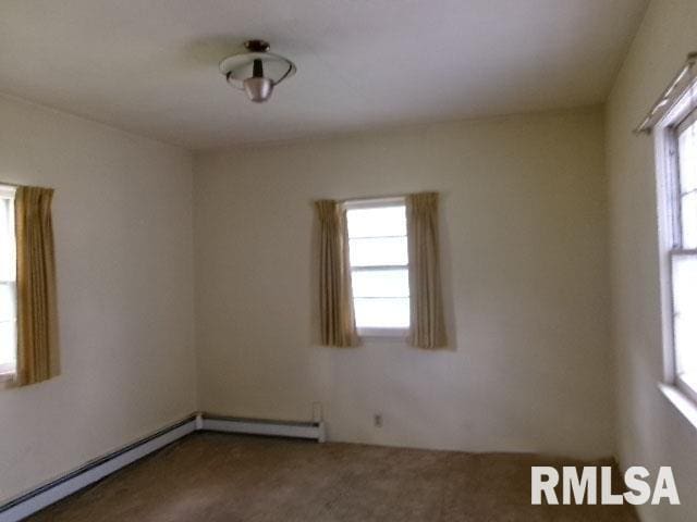 215 N Prairie St, Lacon, IL 61540 - carpeted empty room featuring a baseboard heating unit