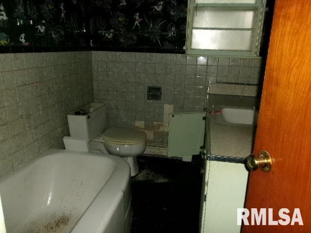 215 N Prairie St, Lacon, IL 61540 - bathroom featuring a bathtub, tile walls, and vanity