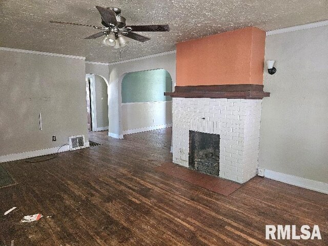 246 E Myrtle St, Canton, IL 61520 - unfurnished living room featuring crown molding, arched walkways, wood finished floors, a ceiling fan, and a brick fireplace