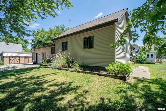611 E Ash St, Canton, IL 61520 - back of property featuring an attached garage, concrete driveway, a lawn, and roof with shingles