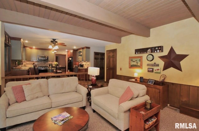 1402 W Grandridge Dr, Dunlap, IL 61525 - carpeted living room featuring wainscoting, a wood ceiling with exposed beams, ceiling fan, and wood walls