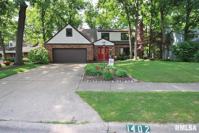 1402 W Grandridge Dr, Dunlap, IL 61525 - traditional home featuring driveway, a front lawn, an attached garage, a chimney, and brick siding