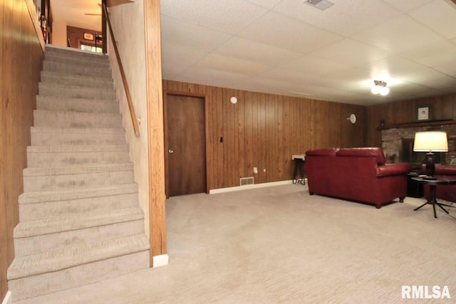 1402 W Grandridge Dr, Dunlap, IL 61525 - carpeted living room featuring stairs, wood walls, and a fireplace