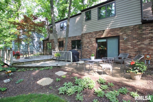 1402 W Grandridge Dr, Dunlap, IL 61525 - rear view of property featuring brick siding and a wooden deck