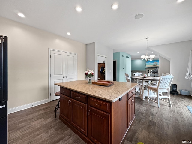 11030 N Ruby Ct, Dunlap, IL 61525 - kitchen featuring dark wood finished floors, a chandelier, a center island, hanging light fixtures, and a kitchen breakfast bar