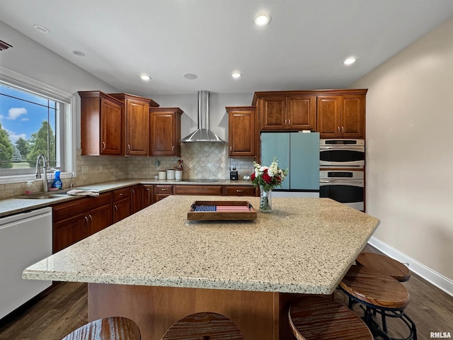 11030 N Ruby Ct, Dunlap, IL 61525 - kitchen featuring wall chimney exhaust hood, stainless steel appliances, a breakfast bar area, dark wood-style floors, and a kitchen island
