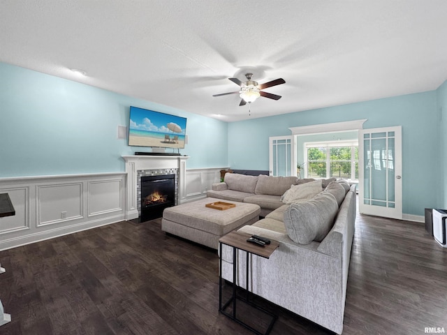 11030 N Ruby Ct, Dunlap, IL 61525 - living room with ceiling fan, a fireplace with flush hearth, dark wood-style floors, and a wainscoted wall
