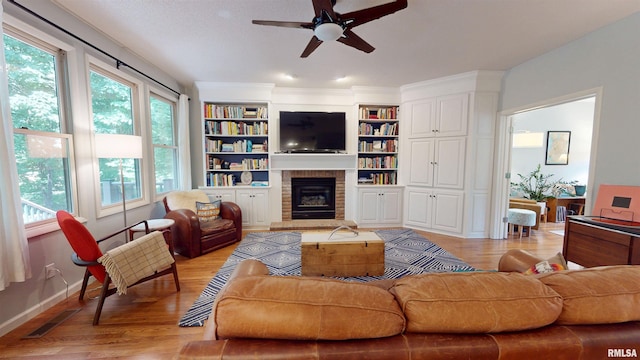 1119 W Brookforest Dr, Peoria, IL 61615 - living room featuring a ceiling fan, a fireplace, light wood-type flooring, and built in features
