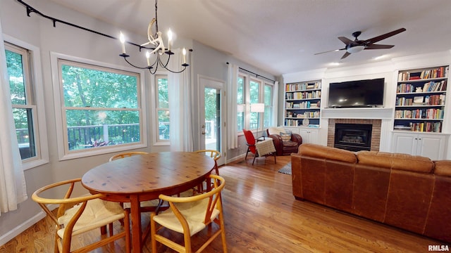1119 W Brookforest Dr, Peoria, IL 61615 - dining room featuring light wood-style flooring, healthy amount of natural light, a brick fireplace, and a chandelier