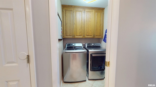 1119 W Brookforest Dr, Peoria, IL 61615 - laundry area with washer and clothes dryer, cabinet space, light tile patterned floors, and a textured ceiling