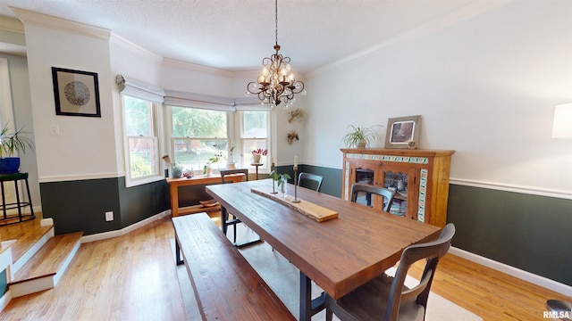 1119 W Brookforest Dr, Peoria, IL 61615 - dining space with light wood-style flooring, ornamental molding, a chandelier, and a textured ceiling