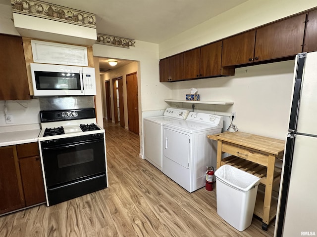 2401 Springfield Rd, East Peoria, IL 61611 - kitchen featuring white appliances, washing machine and dryer, light wood-style floors, light countertops, and dark brown cabinets