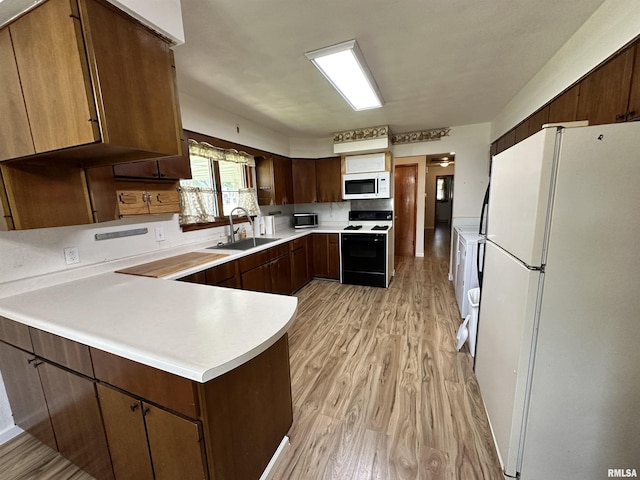 2401 Springfield Rd, East Peoria, IL 61611 - kitchen with white appliances, a peninsula, light countertops, and light wood-style floors
