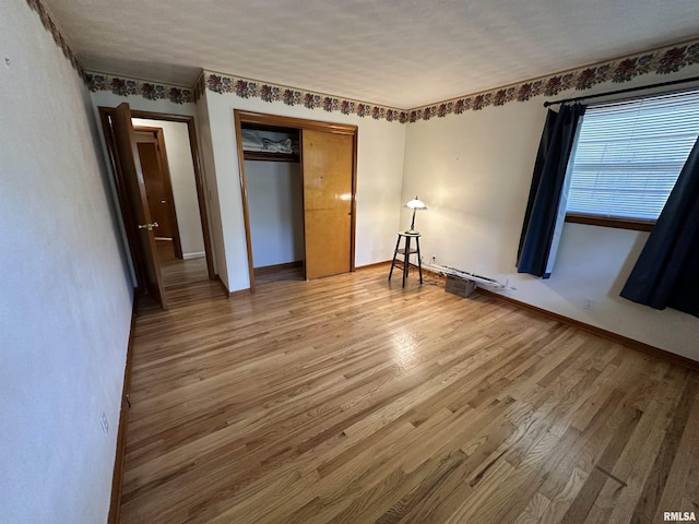 2401 Springfield Rd, East Peoria, IL 61611 - unfurnished bedroom with light wood finished floors and a closet