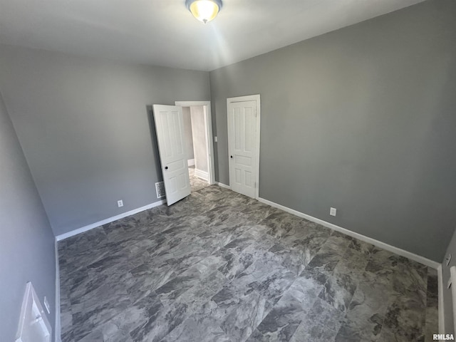 512 Fairholm Ave, Peoria, IL 61603 - unfurnished bedroom featuring baseboards and dark marble finish floors