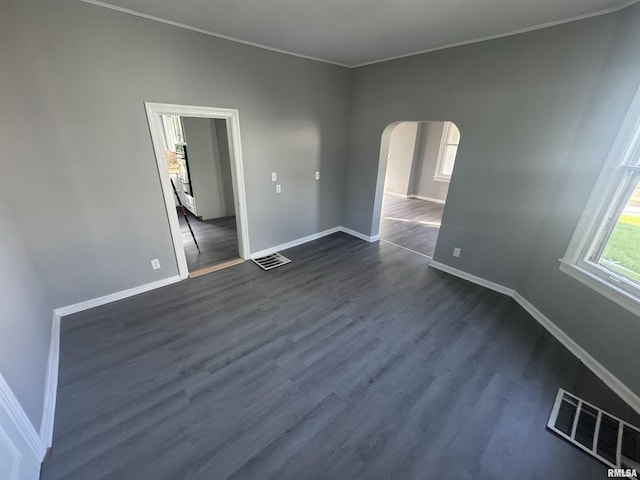 512 Fairholm Ave, Peoria, IL 61603 - spare room featuring arched walkways, ornamental molding, and dark wood finished floors