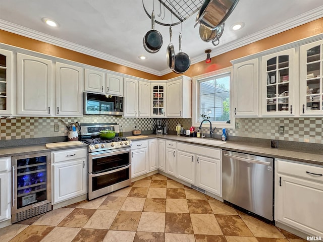 11801 N Deerfield Dr, Dunlap, IL 61525 - kitchen featuring appliances with stainless steel finishes, wine cooler, white cabinets, backsplash, and ornamental molding