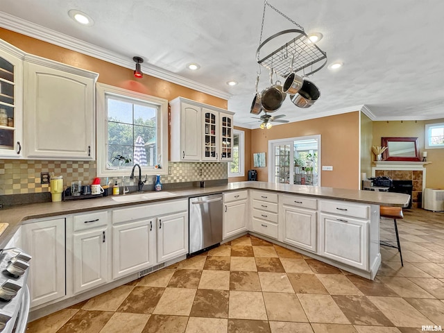 11801 N Deerfield Dr, Dunlap, IL 61525 - kitchen with stainless steel dishwasher, a peninsula, range, a tile fireplace, and backsplash