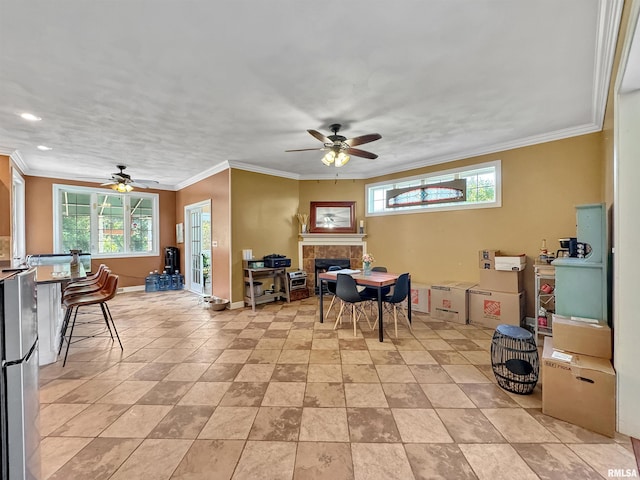 11801 N Deerfield Dr, Dunlap, IL 61525 - dining space featuring a ceiling fan, plenty of natural light, a tiled fireplace, ornamental molding, and recessed lighting