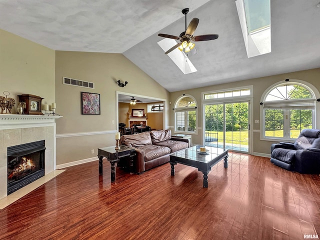 11801 N Deerfield Dr, Dunlap, IL 61525 - living room with a tile fireplace, a ceiling fan, high vaulted ceiling, a skylight, and wood finished floors