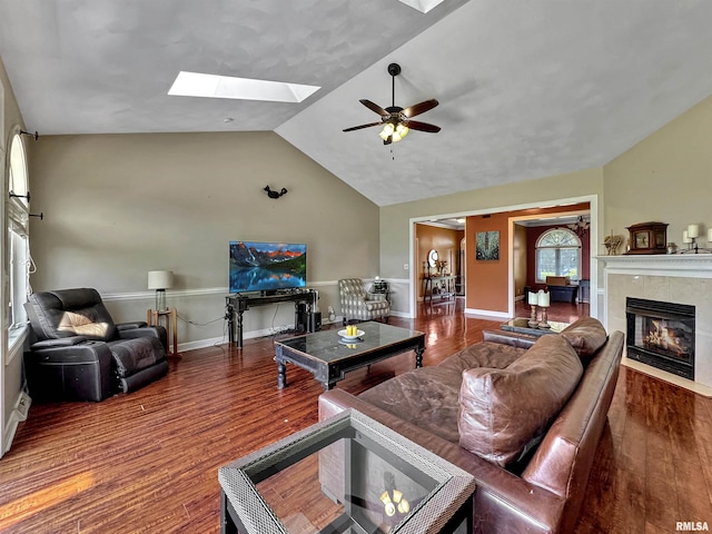 11801 N Deerfield Dr, Dunlap, IL 61525 - living area featuring a skylight, vaulted ceiling, wood finished floors, a ceiling fan, and a tiled fireplace