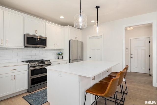 2821 W Lake Trail Ct, Dunlap, IL 61525 - kitchen featuring appliances with stainless steel finishes, a center island, decorative backsplash, recessed lighting, and white cabinetry