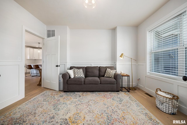 2821 W Lake Trail Ct, Dunlap, IL 61525 - living room featuring wood finished floors, wainscoting, and a decorative wall