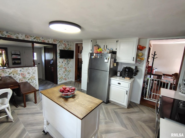 1469 2100th St, Lincoln, IL 62656 - kitchen featuring freestanding refrigerator, white cabinetry, light countertops, and wallpapered walls