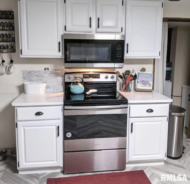 1469 2100th St, Lincoln, IL 62656 - kitchen featuring stainless steel appliances, light countertops, and white cabinets