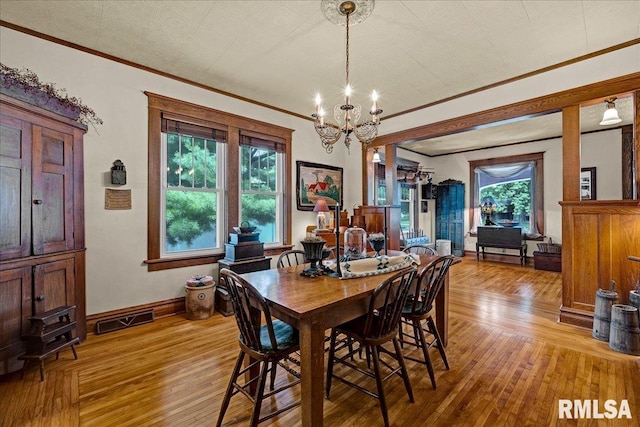 213 S Hanover St, Metamora, IL 61548 - dining area with a chandelier, light wood finished floors, crown molding, and healthy amount of natural light