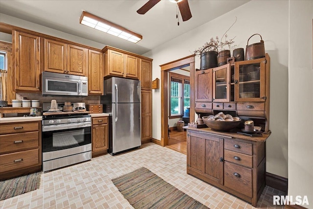 213 S Hanover St, Metamora, IL 61548 - kitchen with stainless steel appliances, ceiling fan, brown cabinets, and decorative backsplash